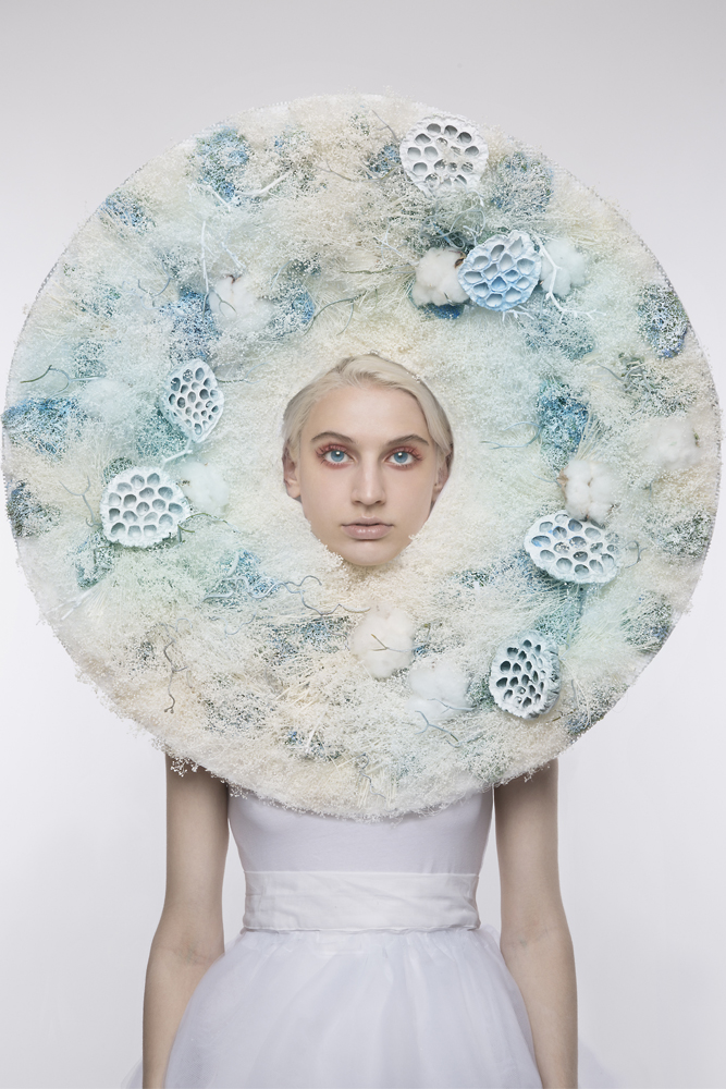 ﻿Woman in all white with large circular prop around face